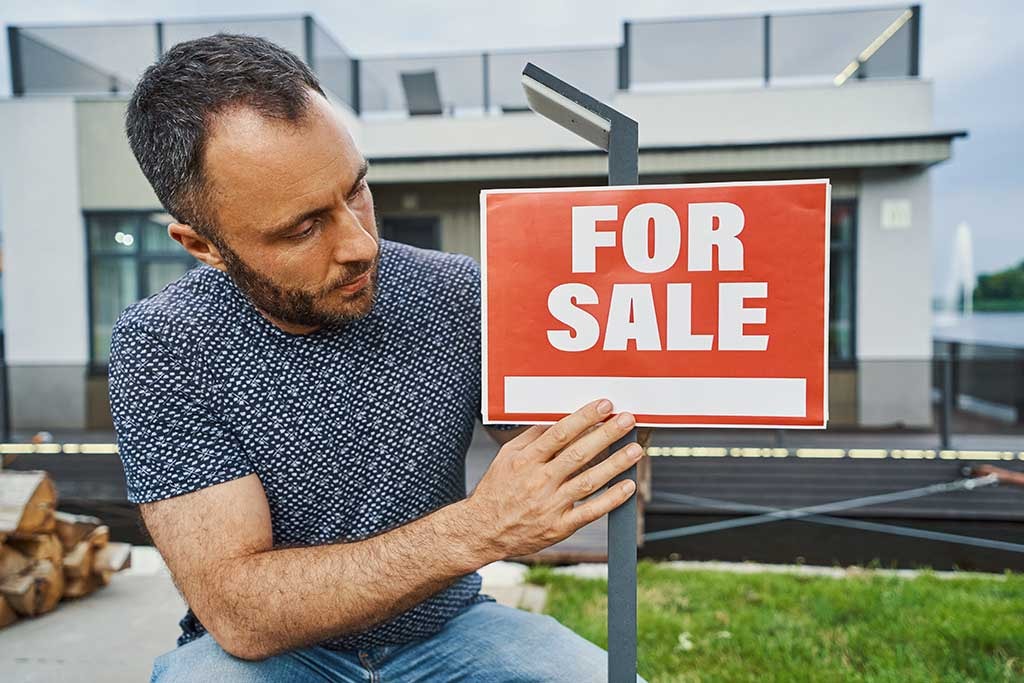 Illustration depicting reasons to sell a house without repairs. Man putting up "For Sale" sign.