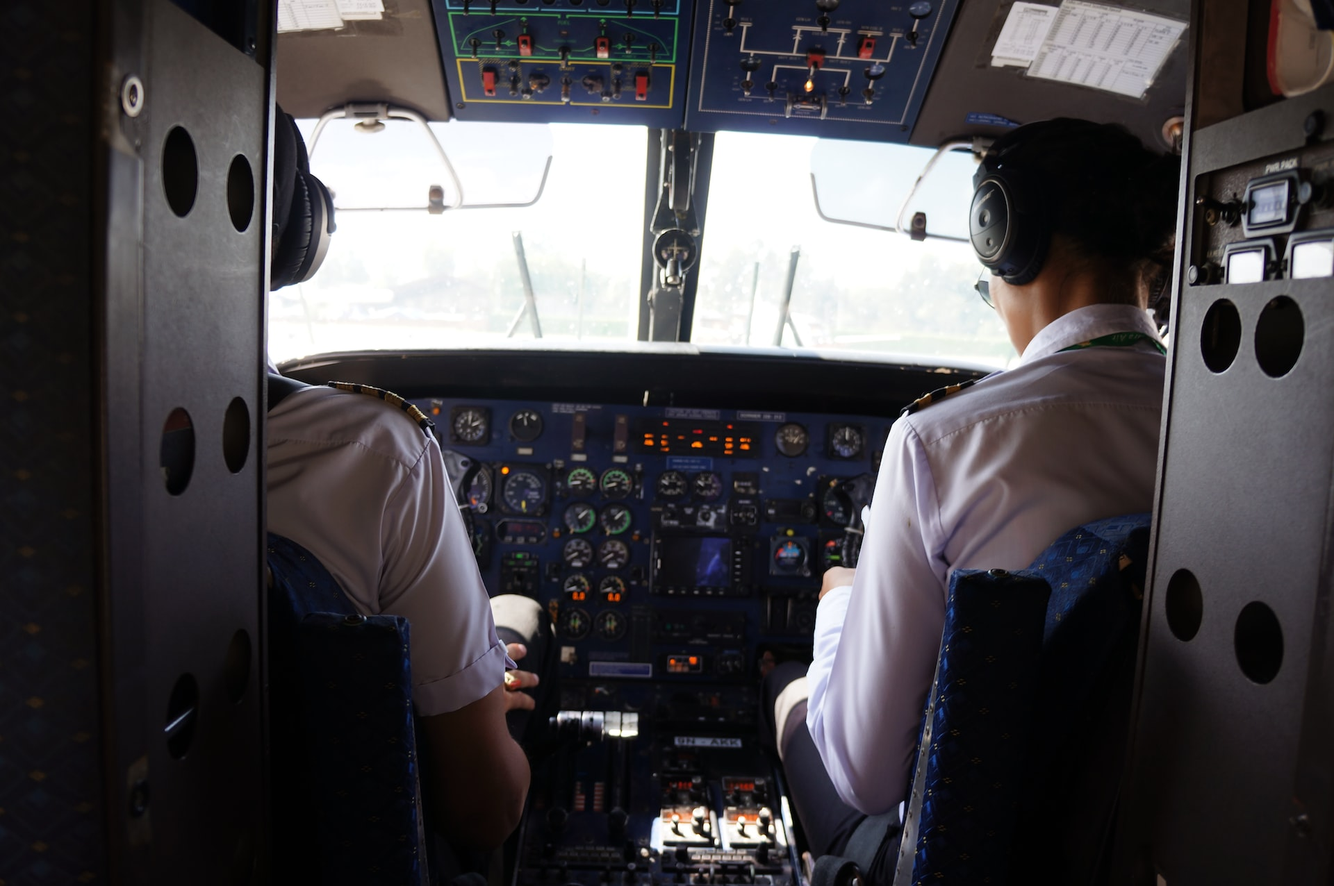 A pilot in command and a first officer sitting in an airplane cockpit.