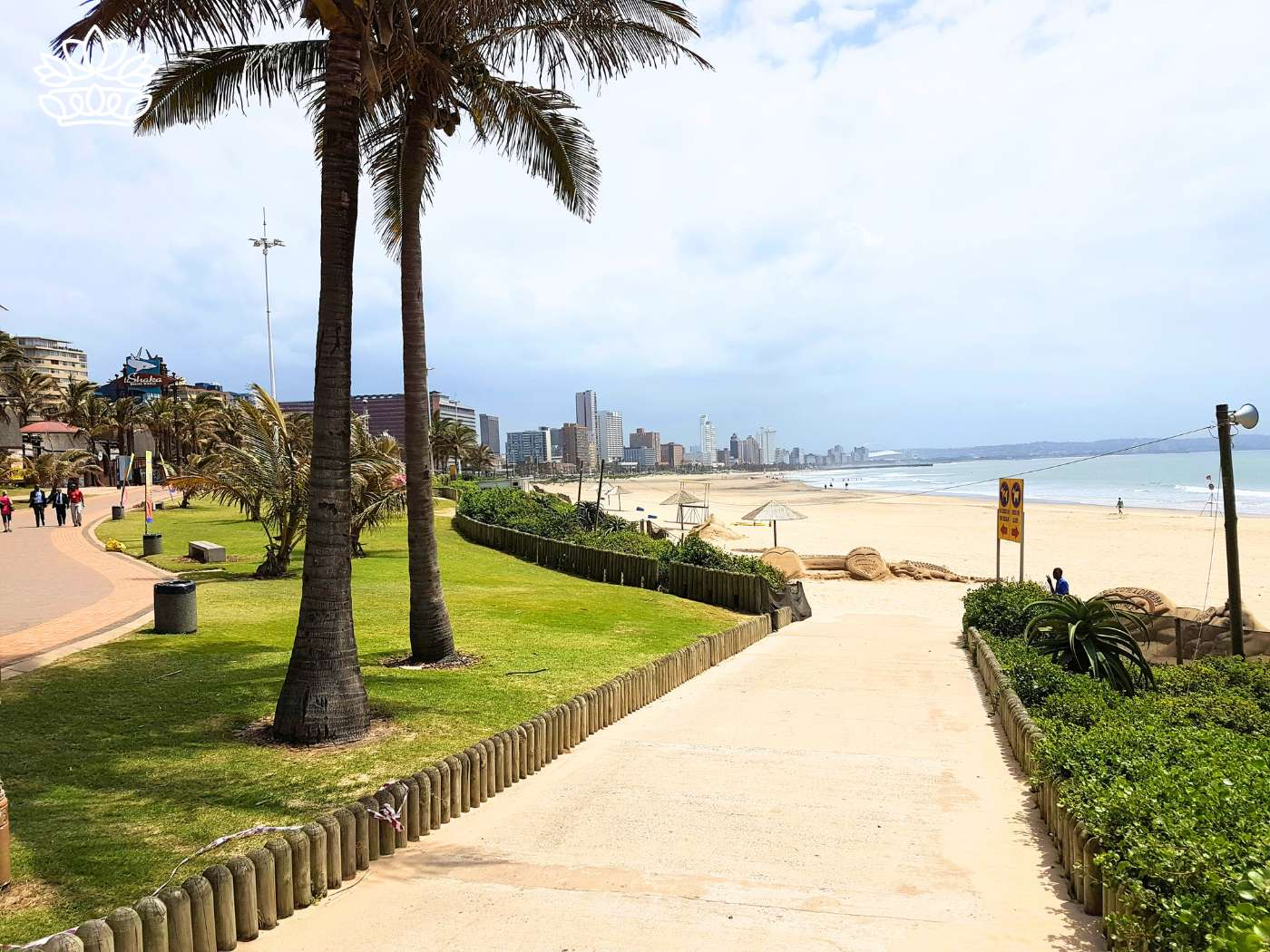 Pathway leading to the sunny Durban beachfront lined with palm trees, representing the Durban Gift Box Delivery Collection with nationwide delivery, where you can send beautiful flowers and gift boxes with excellent service, offered by Fabulous Flowers and Gifts.
