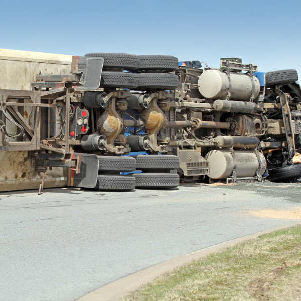 A photograph showing a person taking pictures of an 18 wheeler accident scene for documentation.