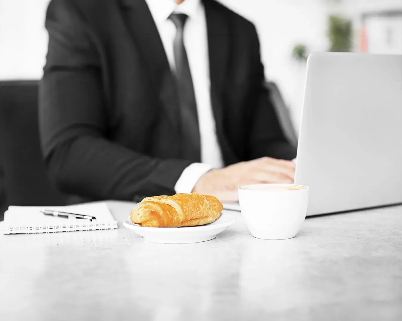 Restaurant marketing consultant working on a laptop beside coffee and pastry, symbolizing local SEO services, restaurant growth strategy, Google search optimization, and digital marketing planning.
