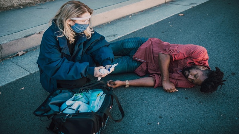 A Woman Giving First Aid to Injured Person