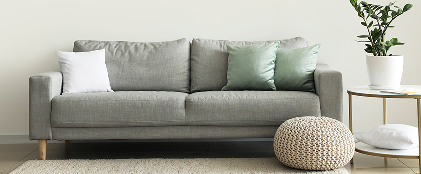 A grey two-seater lawson style sofa has a simple silhouette that suits most rooms and home decor.