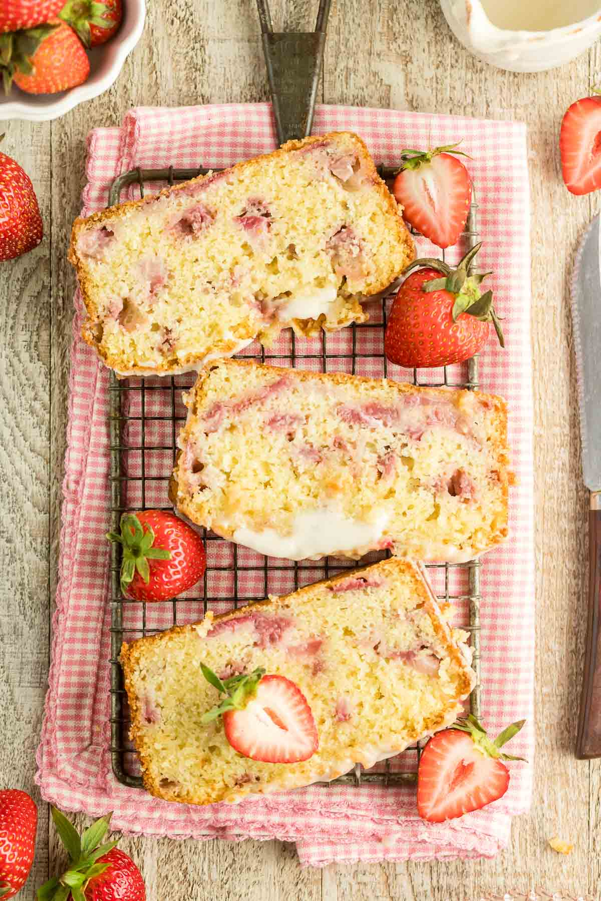 three slices of glazed strawberry bread on a wire rack