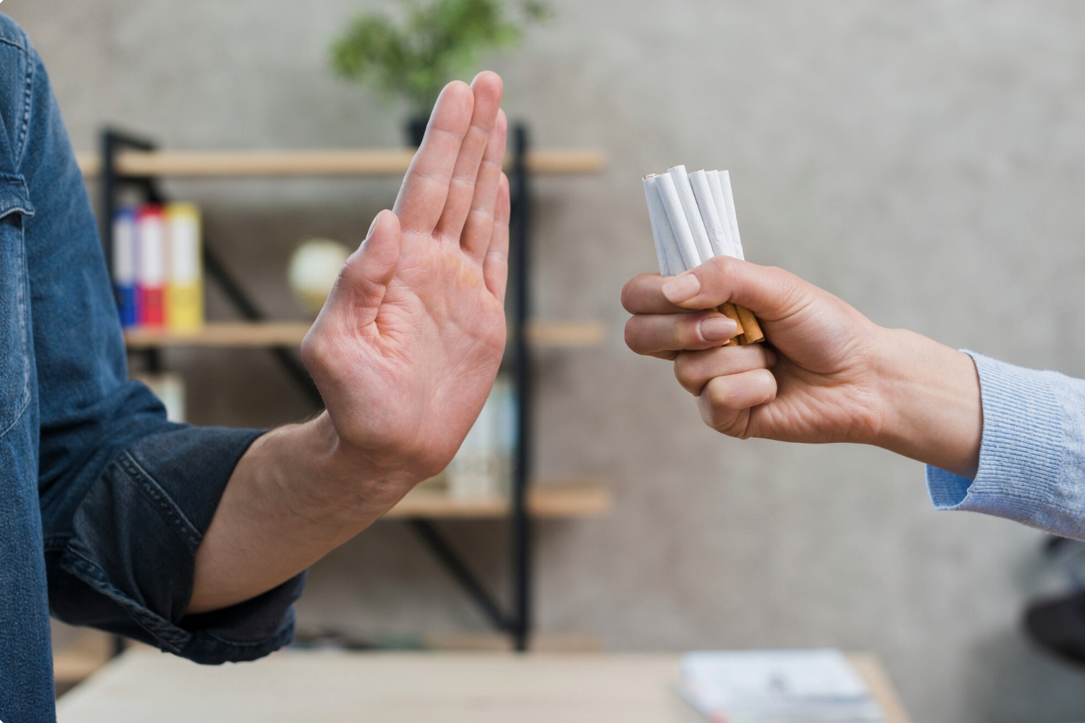 A man rejecting a bunch of cigarettes