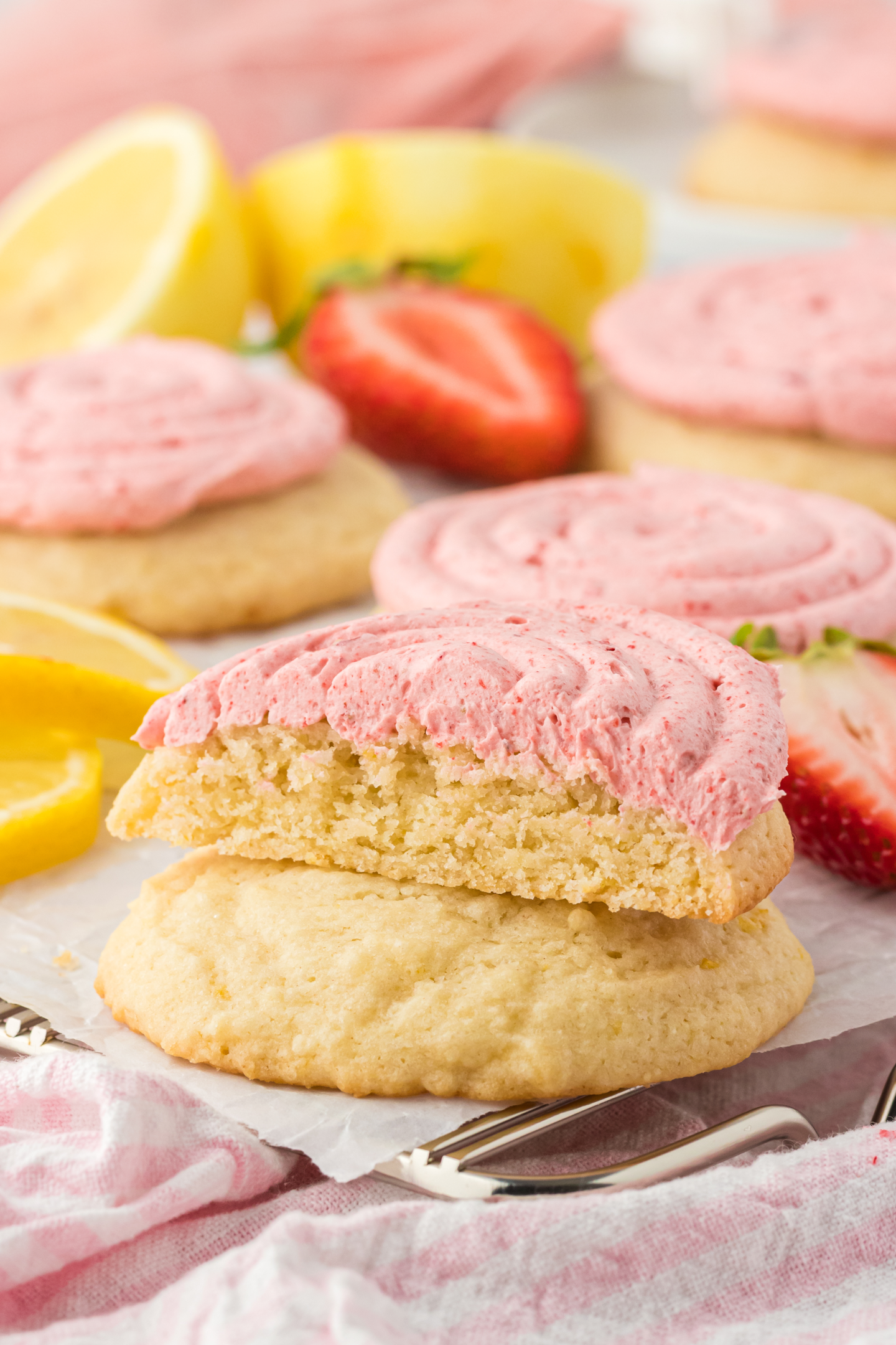 strawberry lemonade cookie cut in half on top of a lemon cookie on a cooling rack