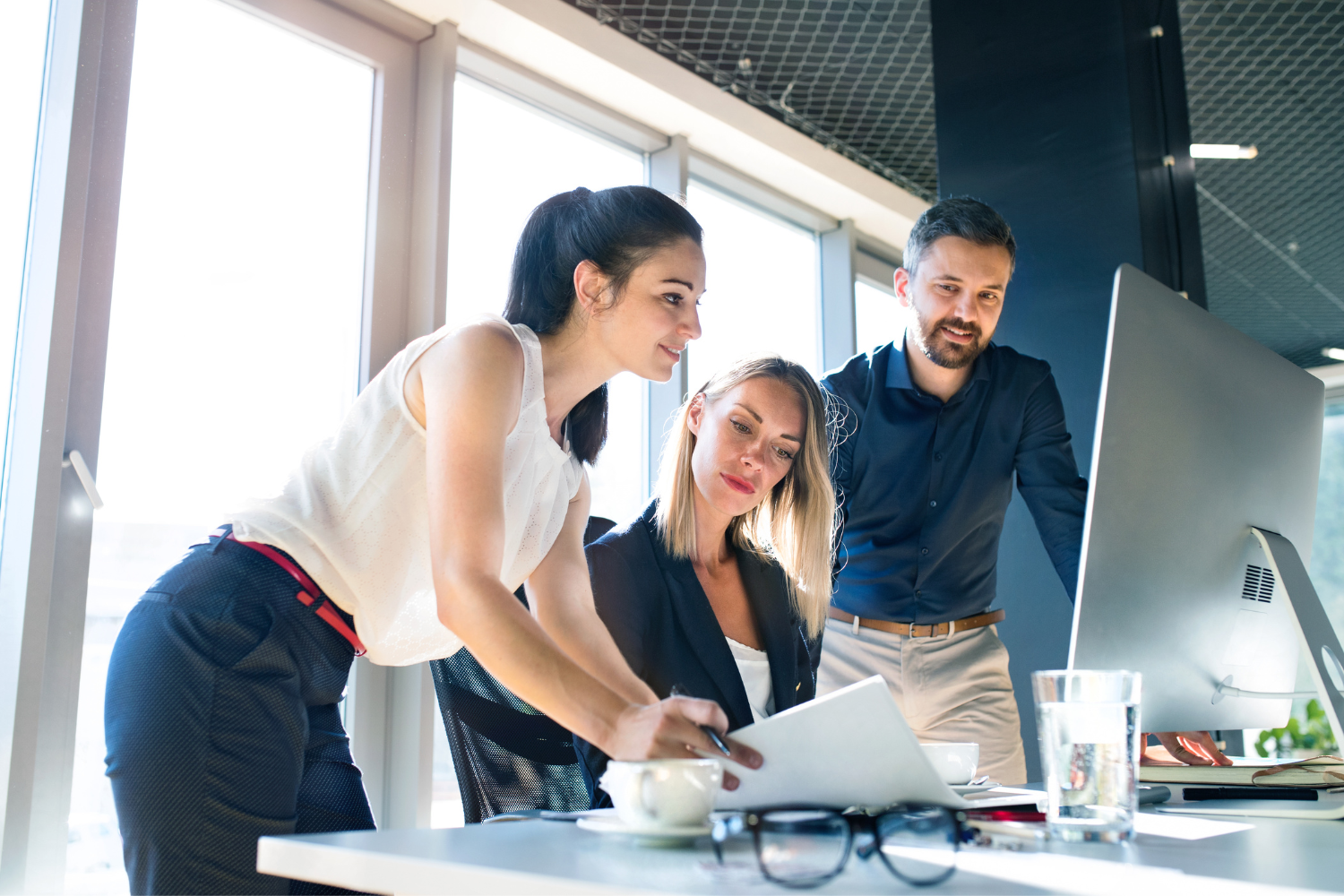 A team of Western employees, looking at a desktop.