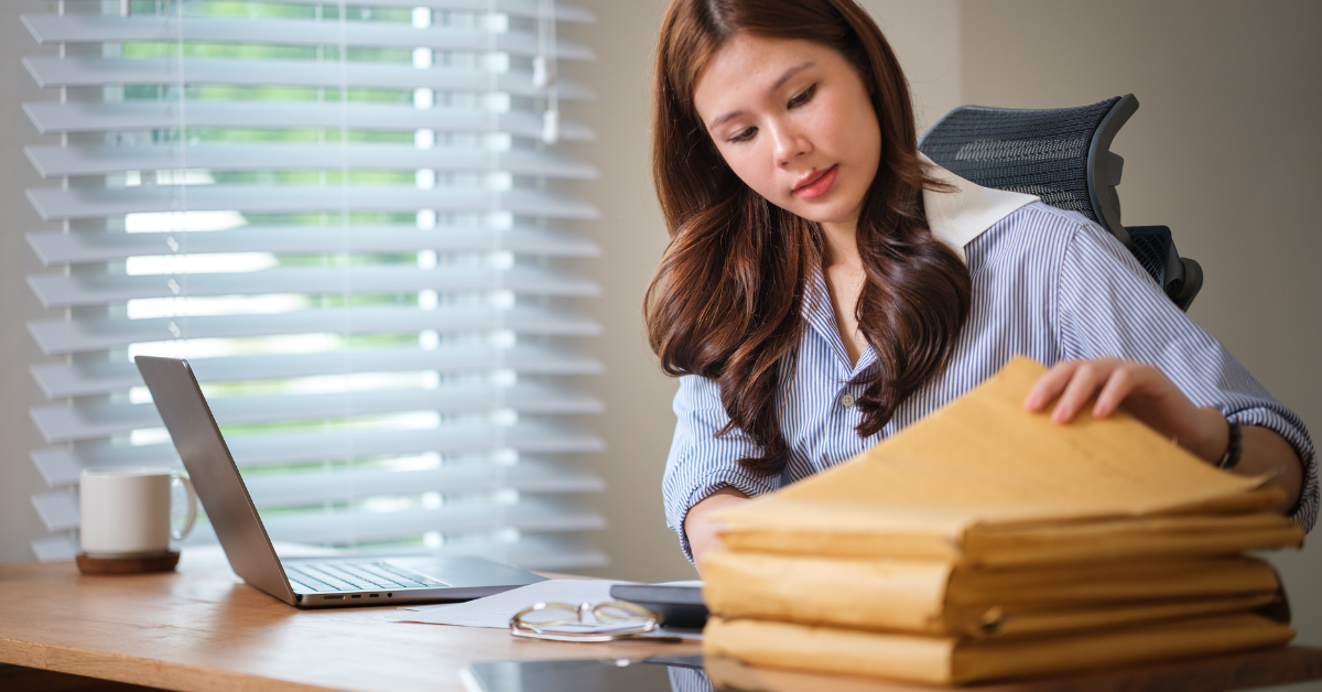 Woman organizing financial records to track current and noncurrent assets for her OnlyFans business.