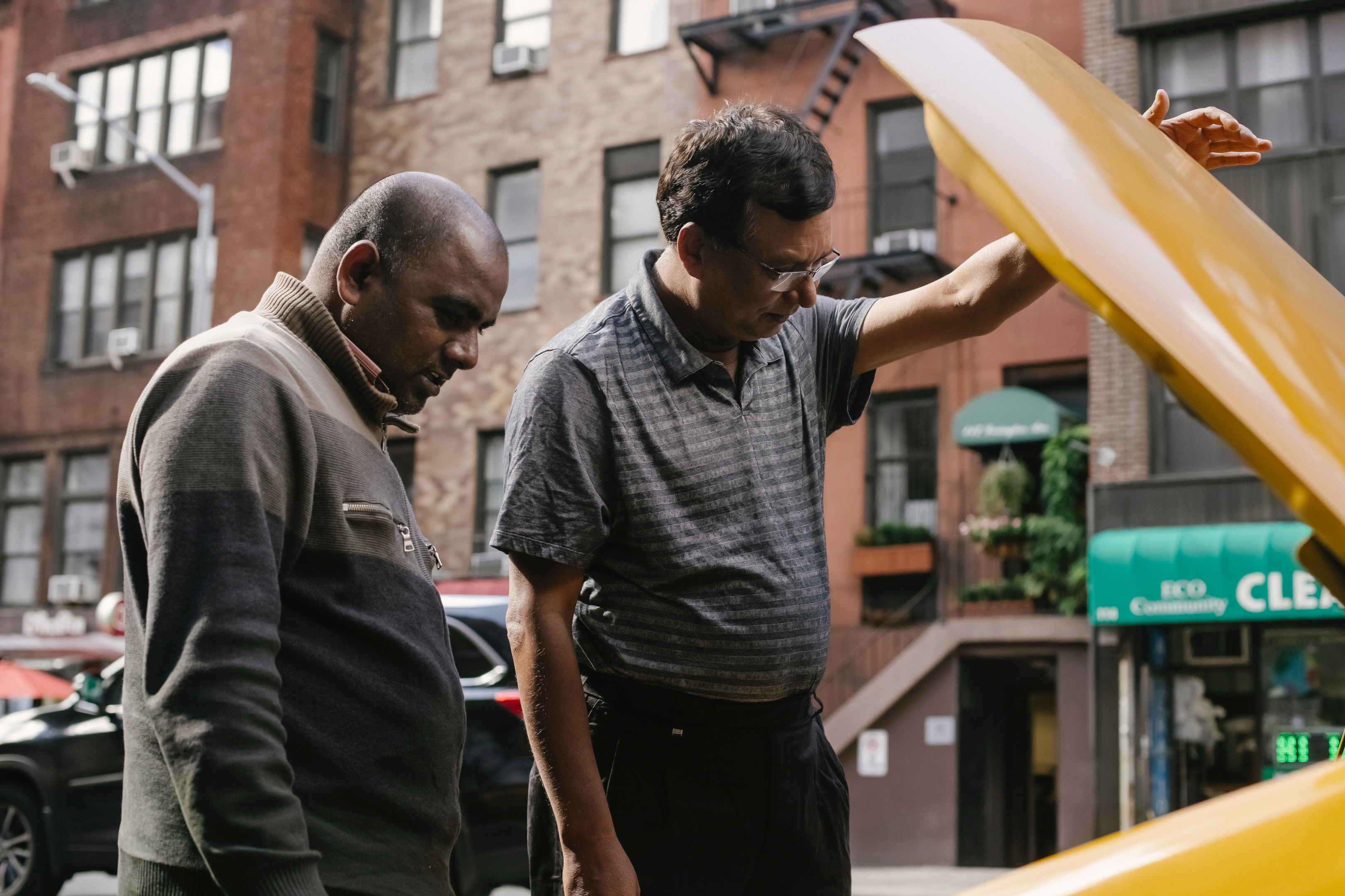 Two man inspecting car engine, potential car buyer