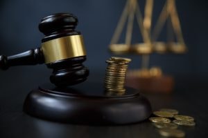 A black and gold Judge's gavel sitting on a black background