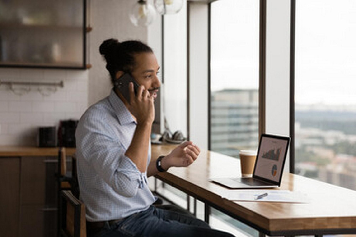 A man talking on a cell phone through a cloud phone system.