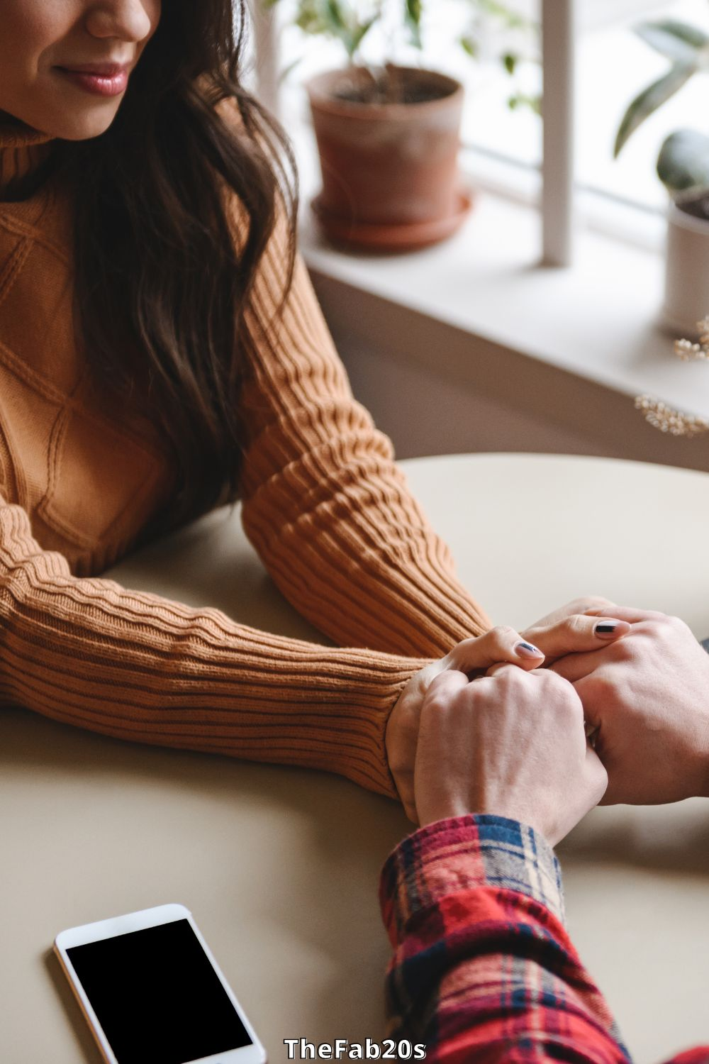 Girl holding hands over a table with a man - Should you take your ex back after they dumped you?