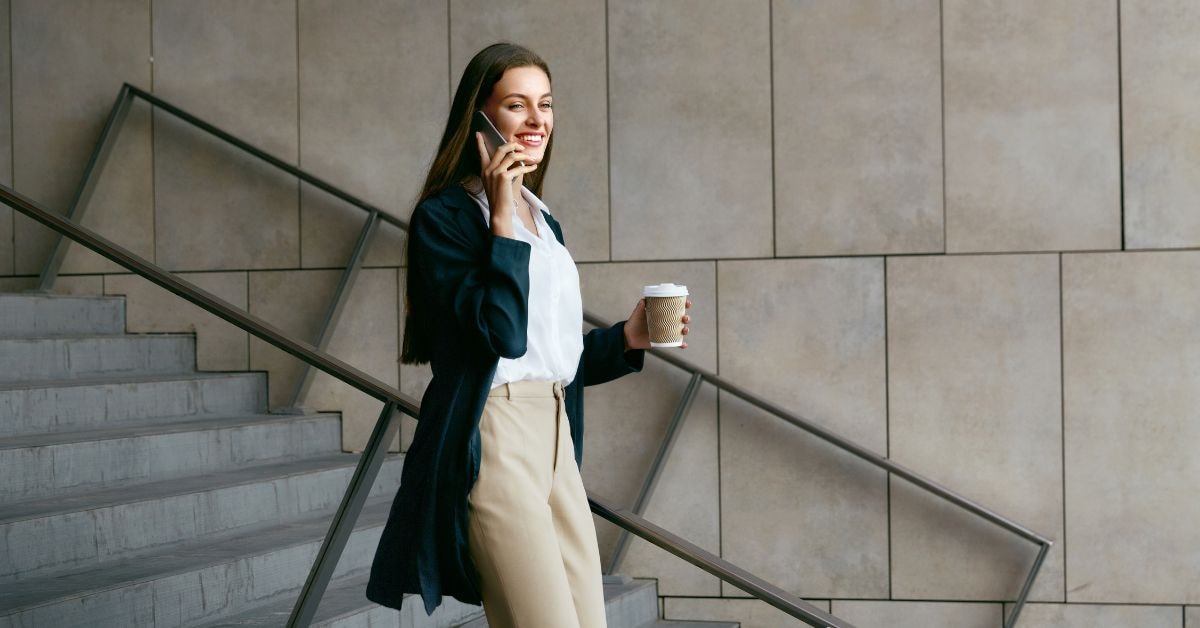 OnlyFans creator talking on the phone while holding a coffee, highlighting the benefits of hiring a local tax accountant.