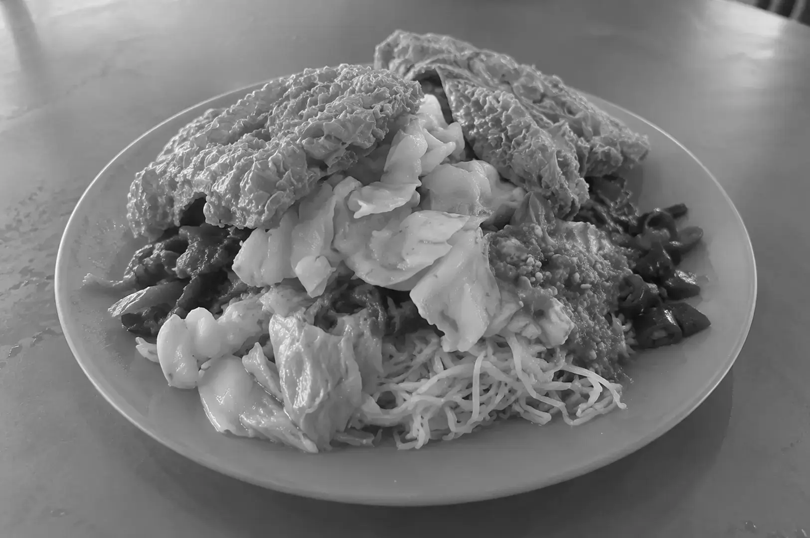 Vegetarian bee hoon served on a plate with thin rice vermicelli, vegetables, and meat-free accompaniments.