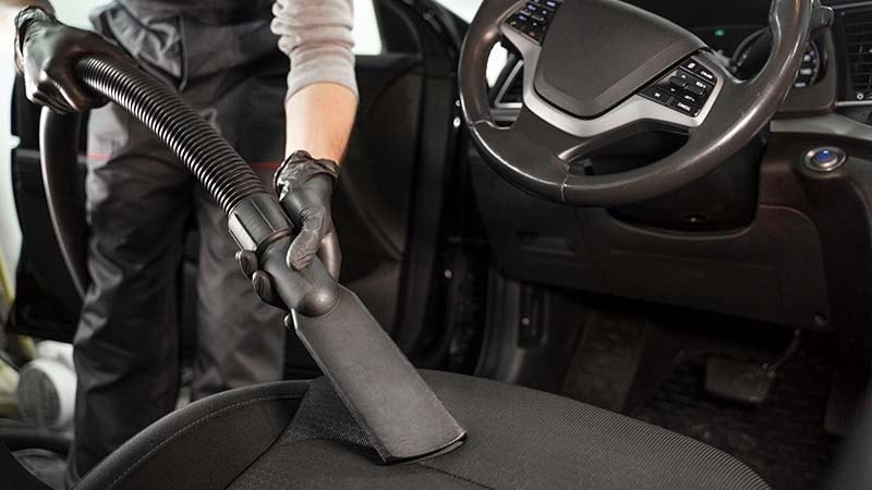 Man vacuuming car seat