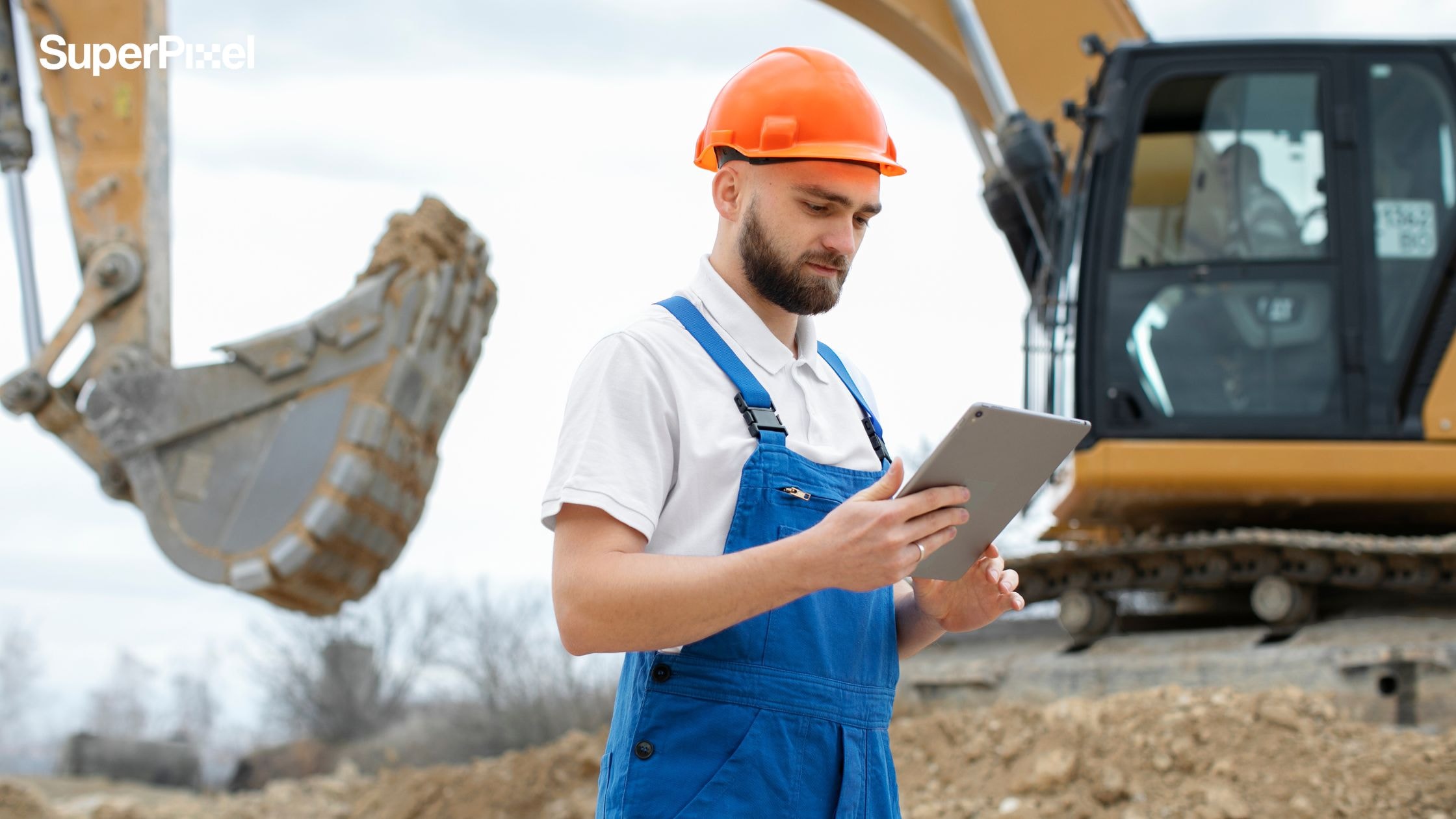 A person working in building construction holding a tablet for communication (dok.freepik)