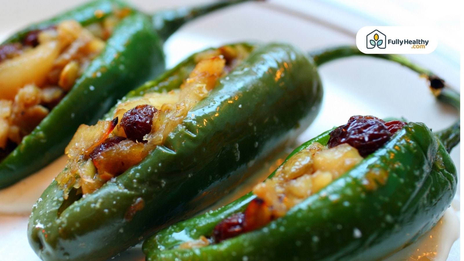 Stuffed jalapeño peppers filled with savory mixture on white plate