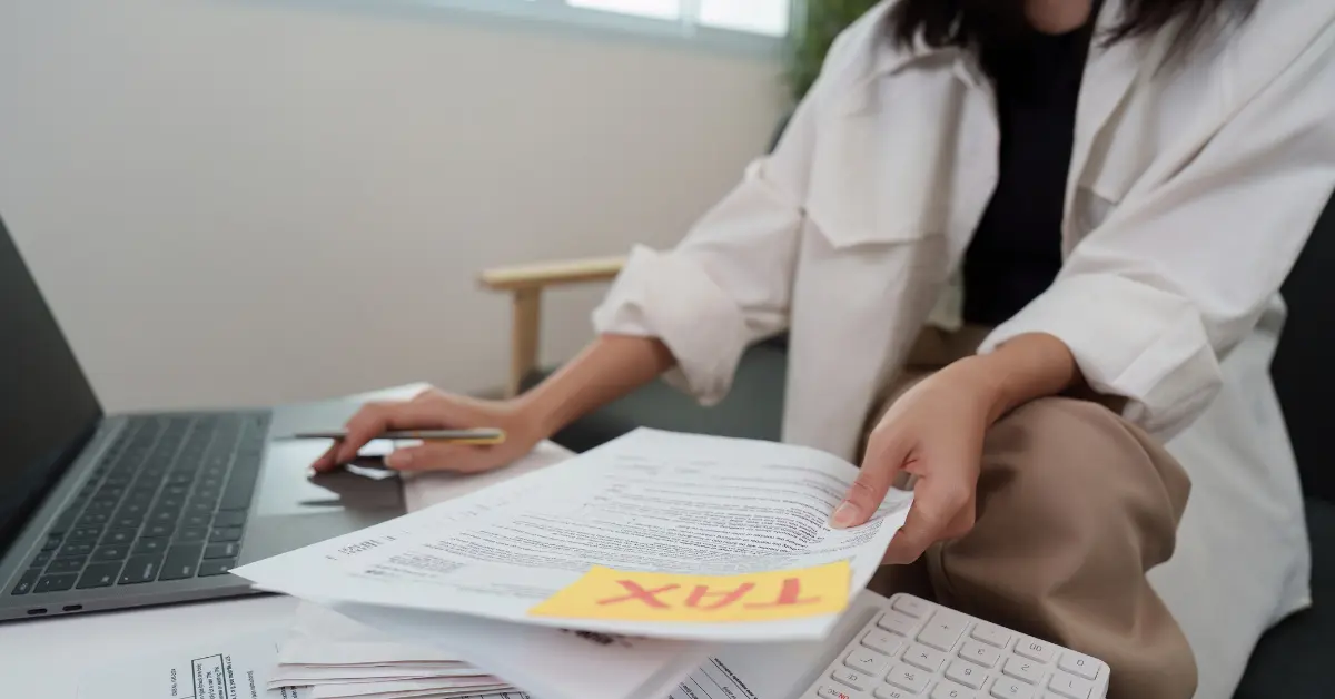 Woman organizing 1099 forms and calendar asking can I do my taxes early?