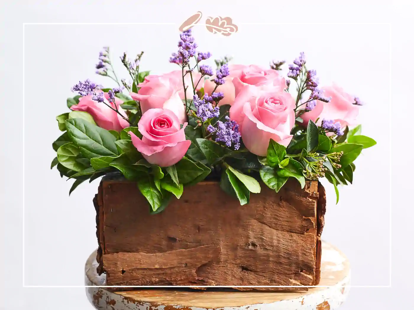 A charming wooden box filled with pink roses and lavender accents. Fabulous Flowers and Gifts