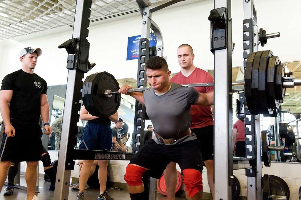 Squat barbell hurts neck during a heavy back squat with the bar resting high on the upper back.