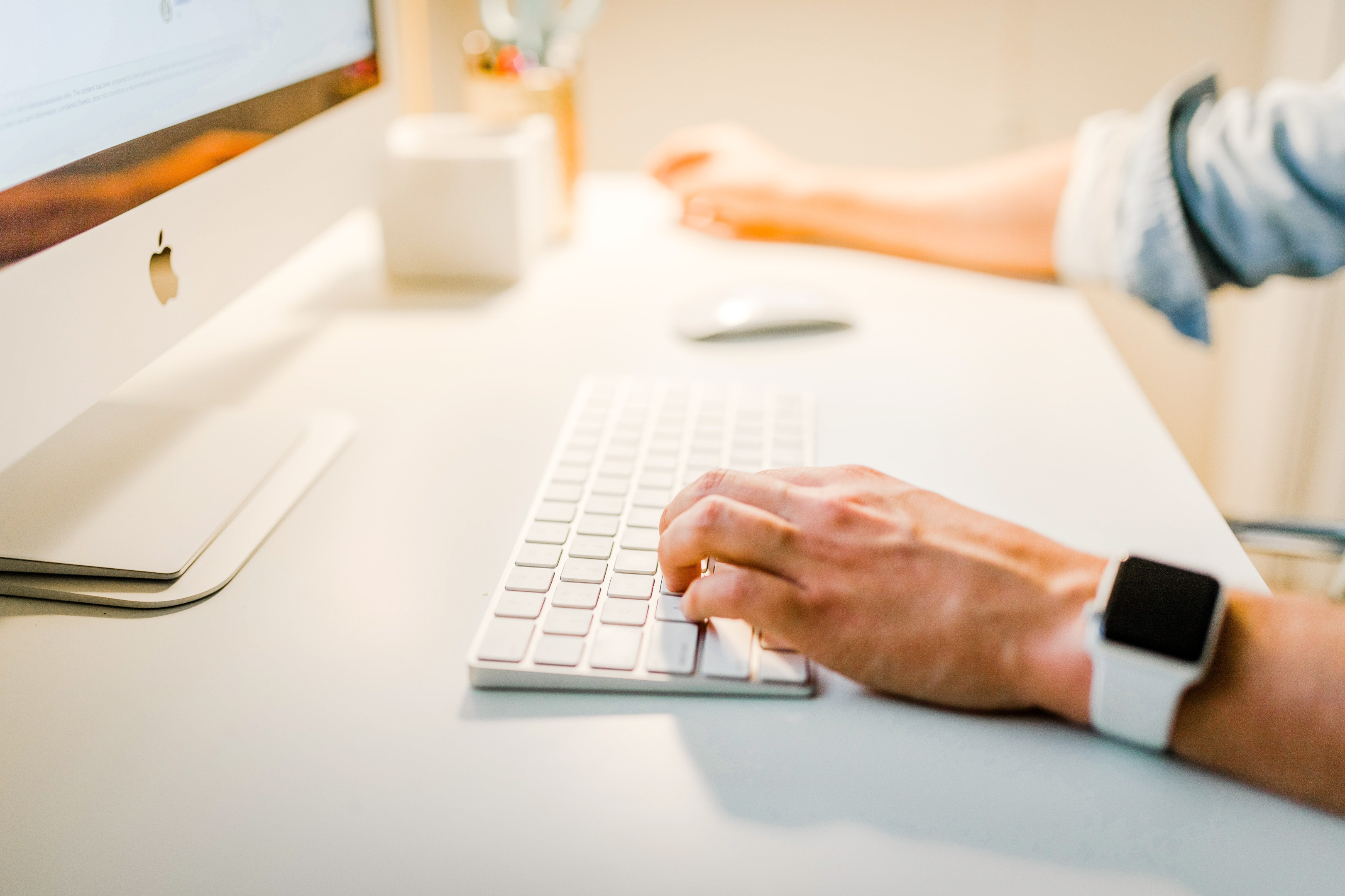 Photo of a person's hand typing on an iMac keyboard. 5 Actions to Take When You Get a New Client | Brittany Corporation