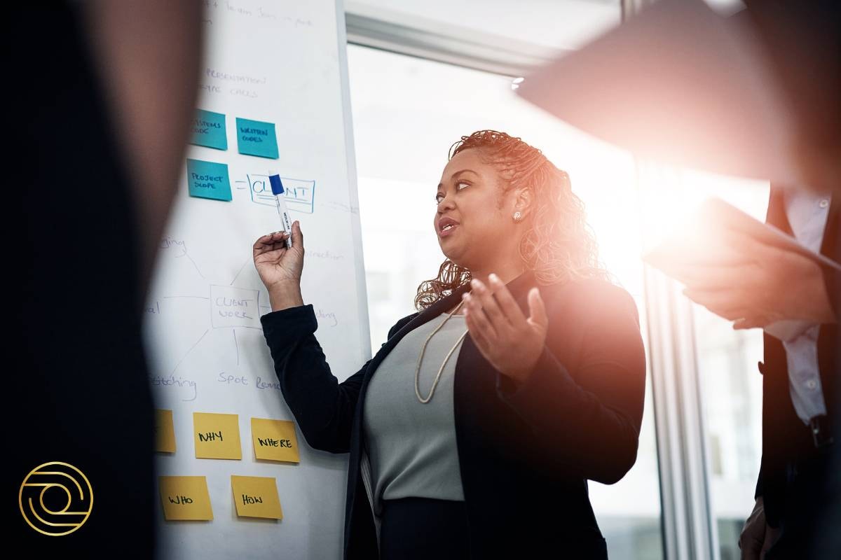 Businesswoman highlighting client-focused workflow processes during a presentation at ACTIVE© Project Management.