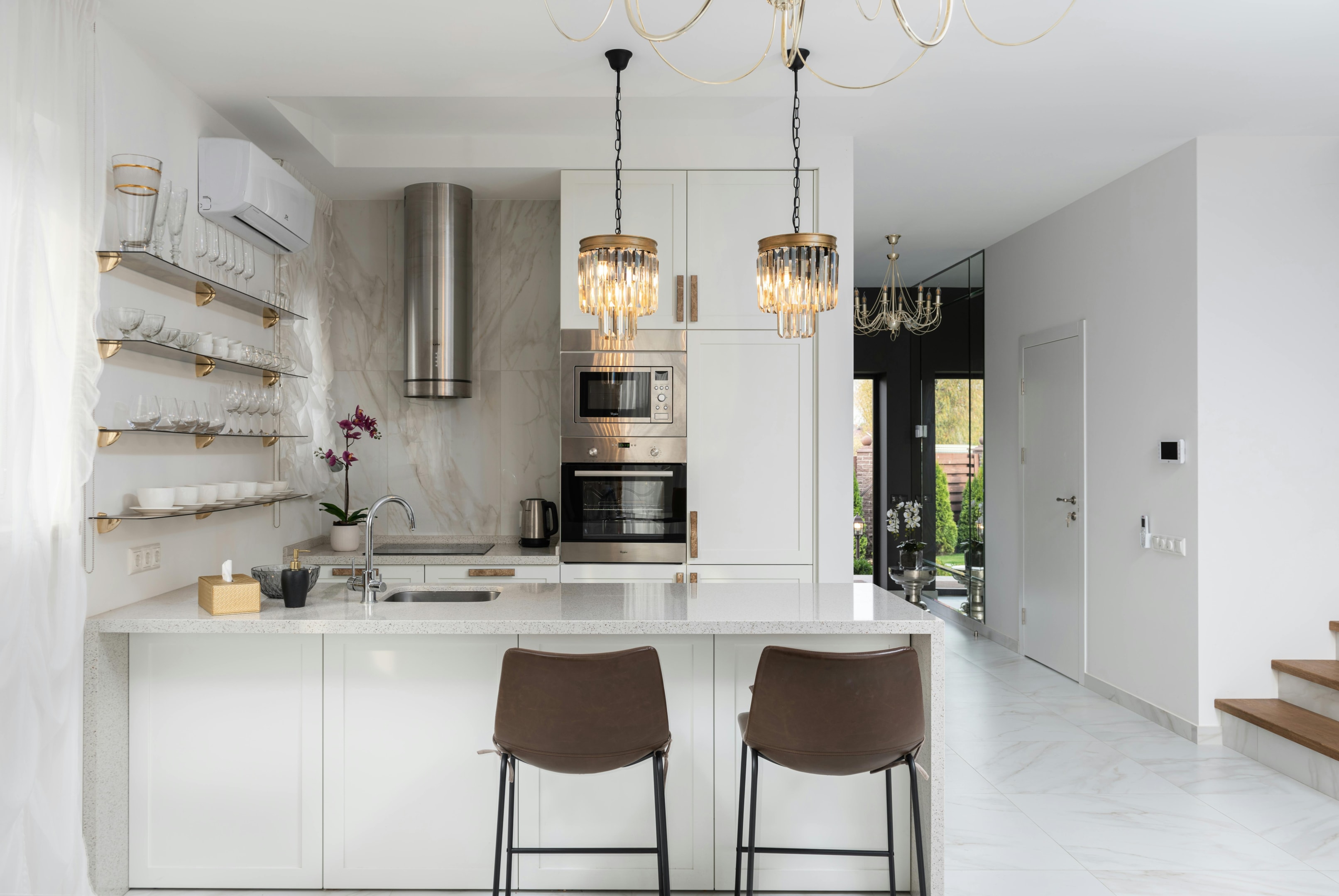 A modern kitchen interior featuring sleek custom cabinetry, a spacious kitchen island with pendant lighting, stainless steel appliances, and a stylish backsplash, creating a functional and aesthetically pleasing space.