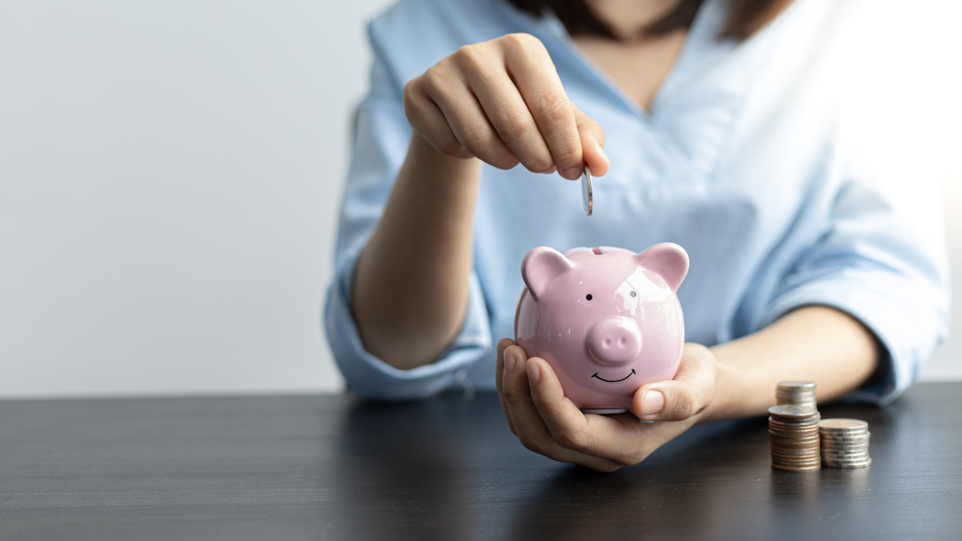 woman putting money into piggy bank