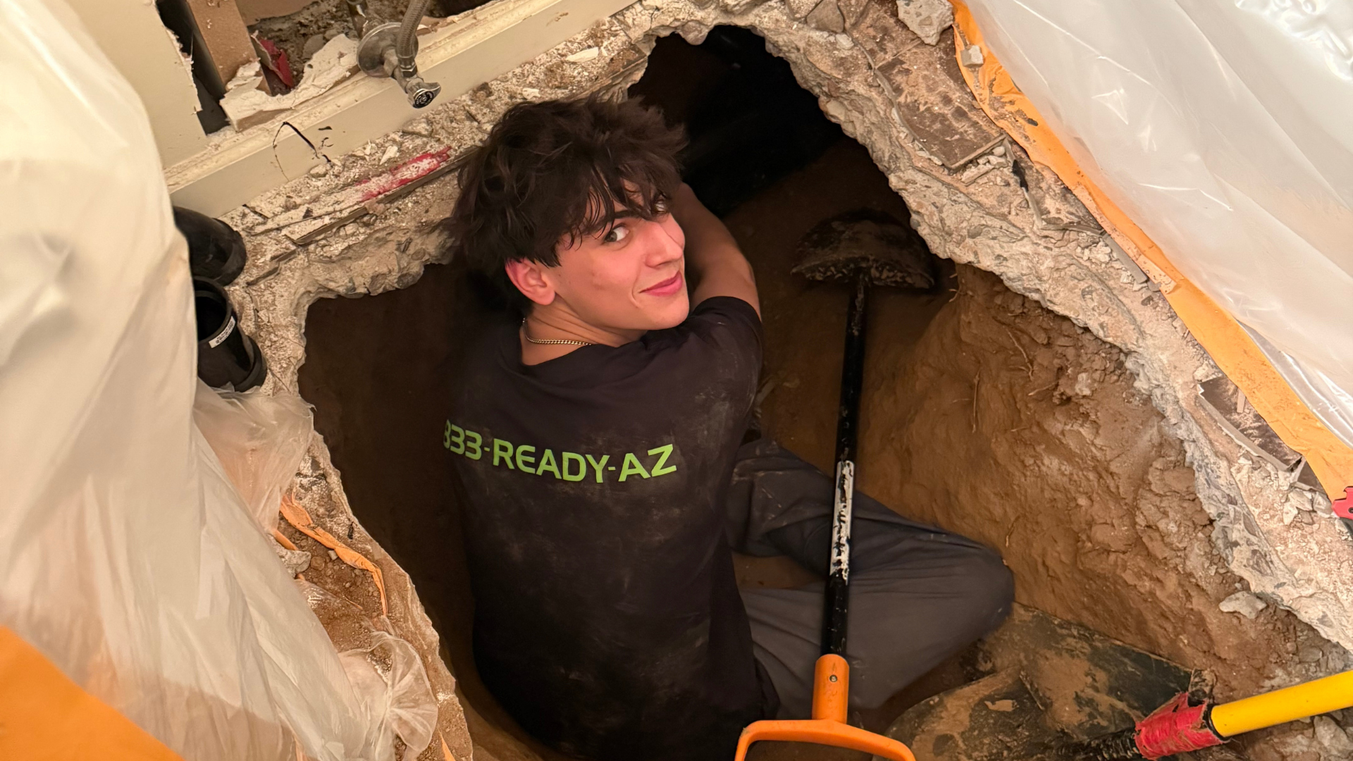 A professional plumber is using a handheld thermal imaging camera to inspect a tiled floor in a residential home, looking for signs of hidden leaks or moisture that could indicate potential water damage. The advanced tools help in detecting any small leaks that may not be visible to the naked eye, ensuring accurate leak detection and prevention of high water bills.