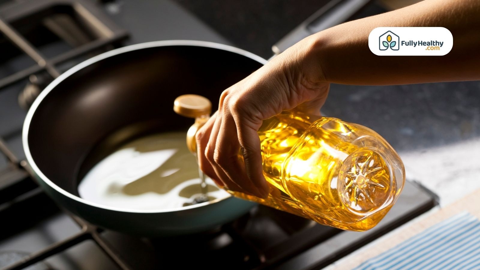 Hand pouring avocado oil into nonstick frying pan on gas stove