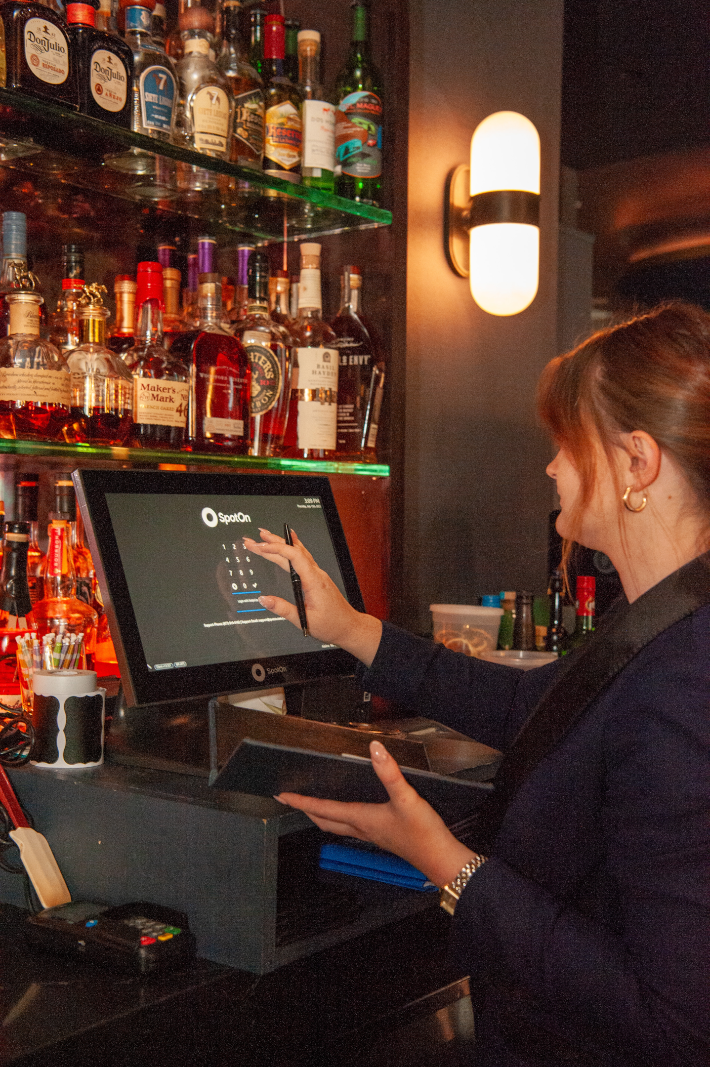 Bartender using the SpotOn POS system for bars and restaurants to make an order.