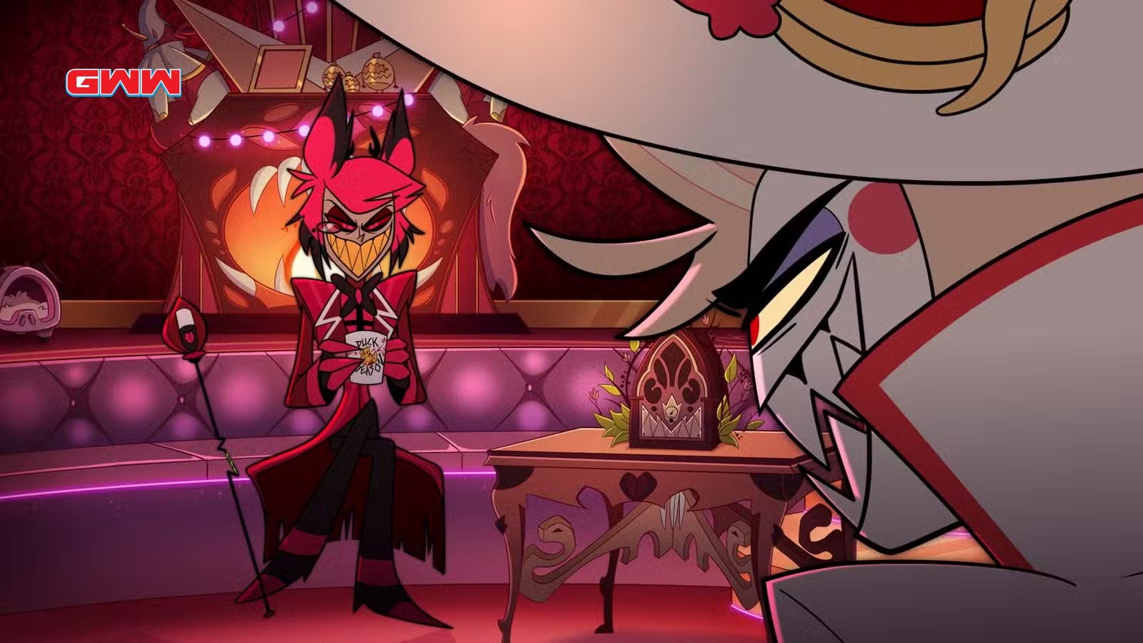 Amir Talai as Alastor smirks in lounge with Jeremy Jordan as Lucifer Morningstar in Hazbin Hotel season 2