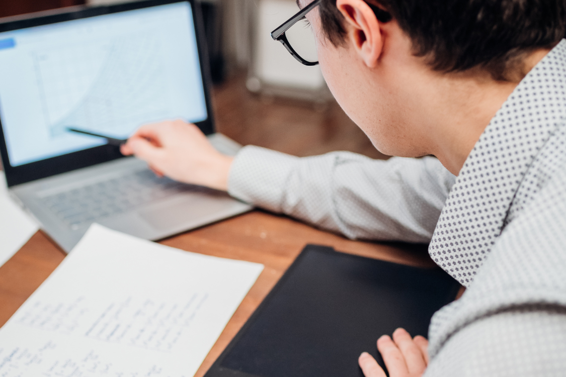 Remote worker reviewing charts and writing notes for a test project
