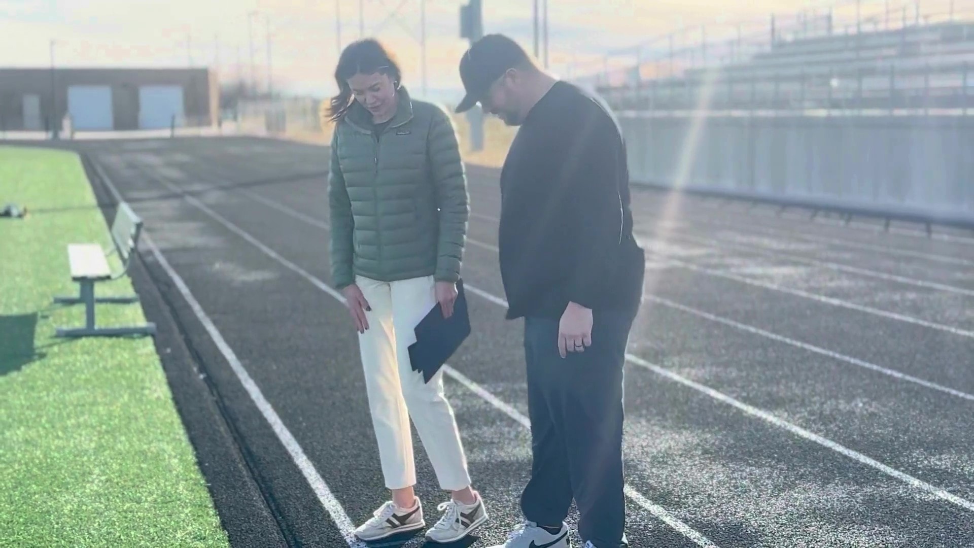 Facility managers reviewing running track surface condition during site evaluation.