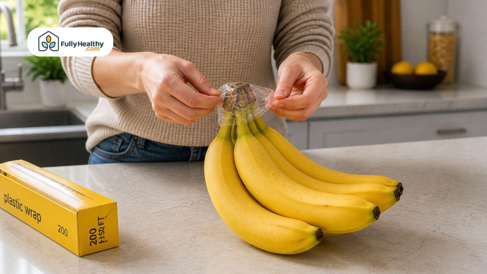 Wrapping banana stems with plastic wrap to slow ripening process