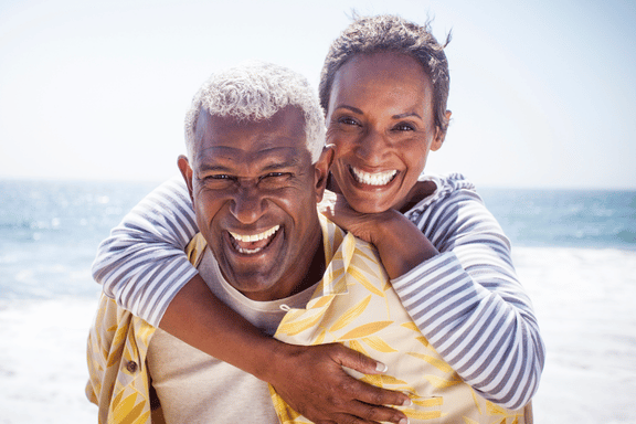 senior couple smiling who chose a dental implant to replace missing tooth