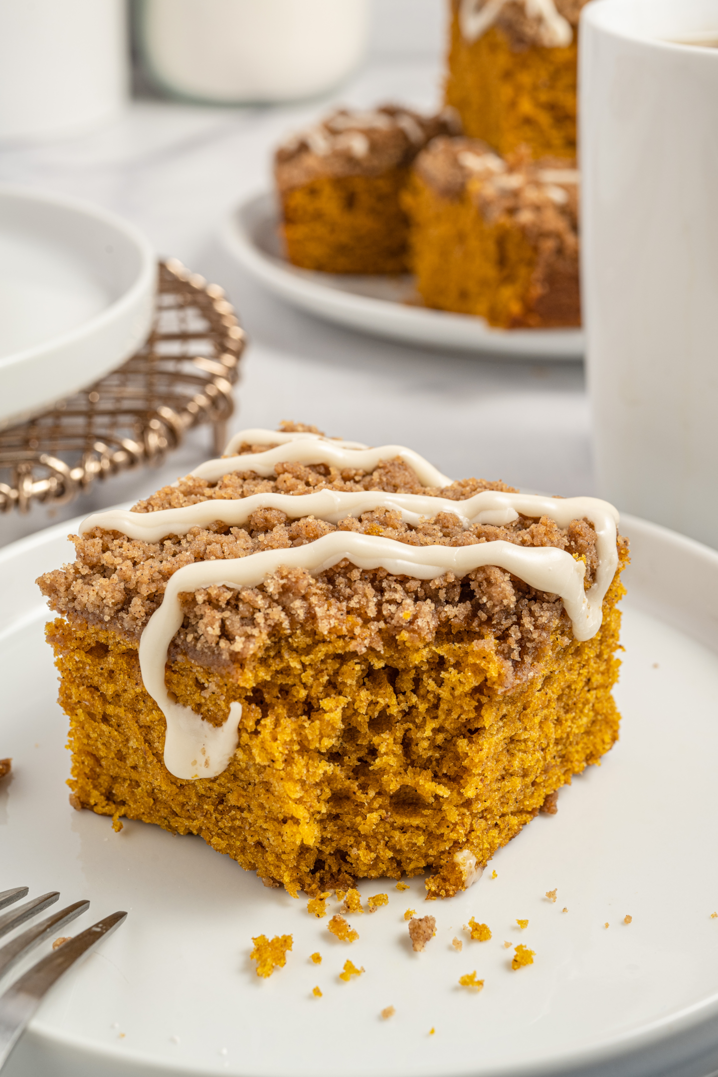 slice of pumpkin coffee cake on a plate with a bite missing