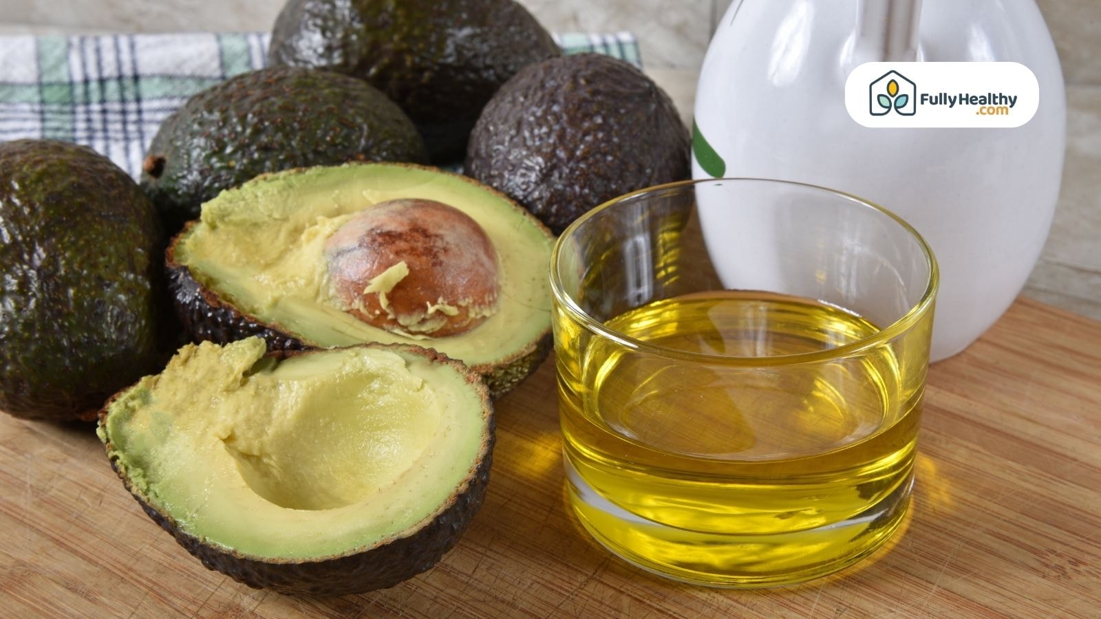 Ripe avocado beside glass of pure avocado oil