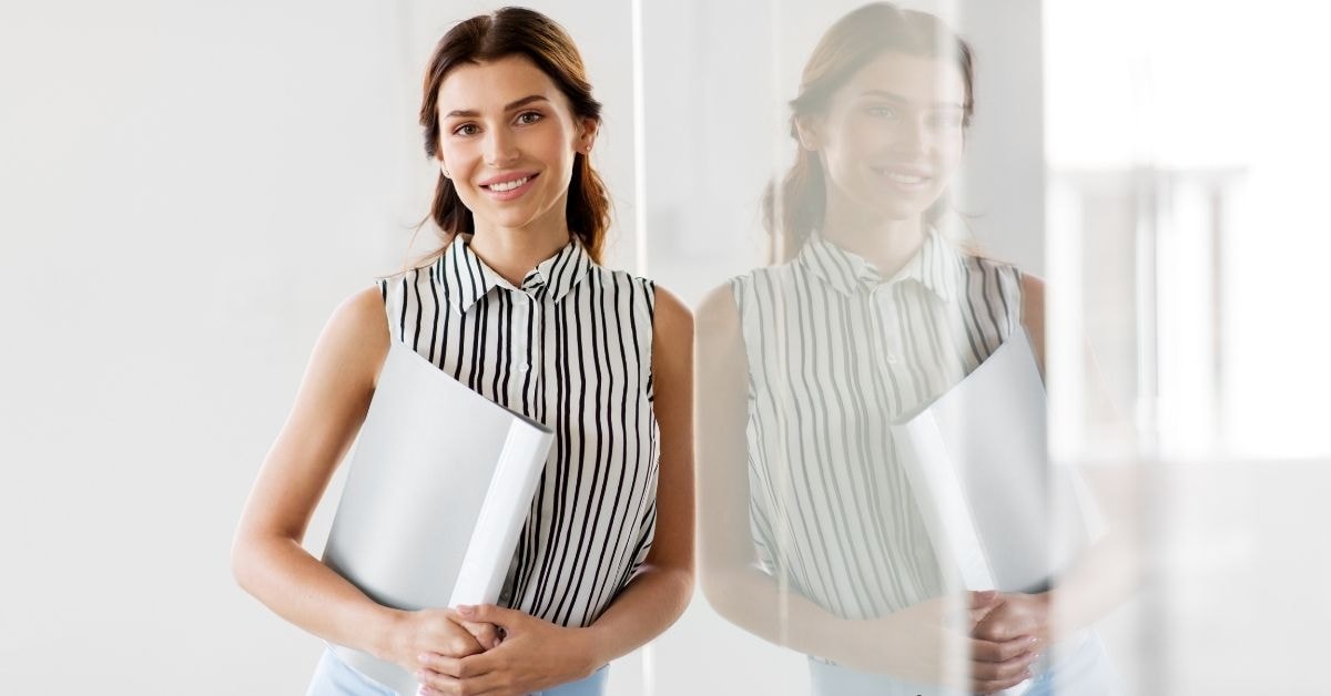 Smiling professional woman holding documents related to Form W-2G and income reporting.