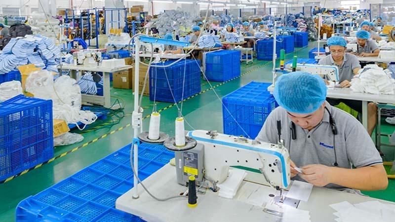 Workers hand-stitching microfiber cloths