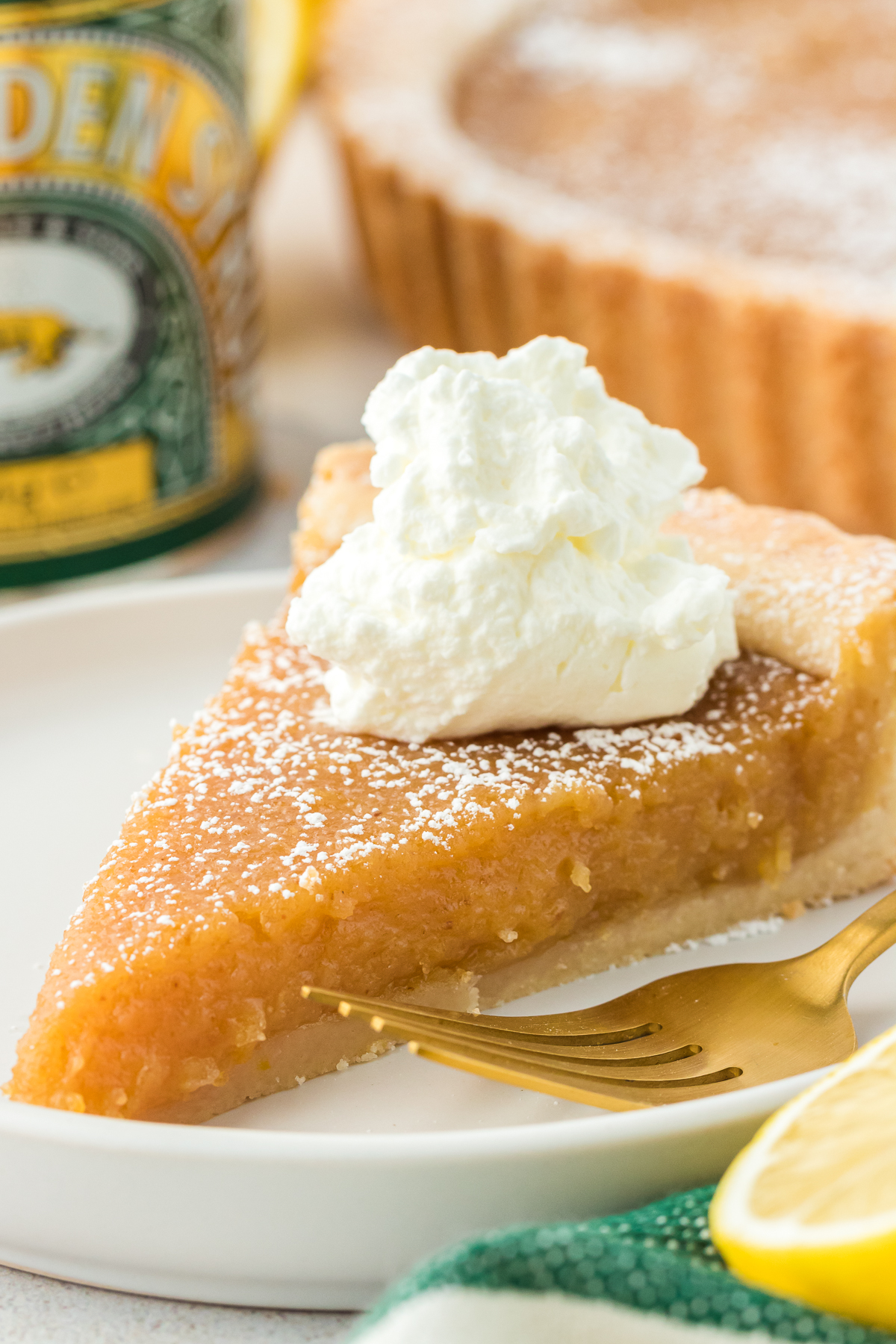 slice of treacle tart on a plate topped with whipped cream