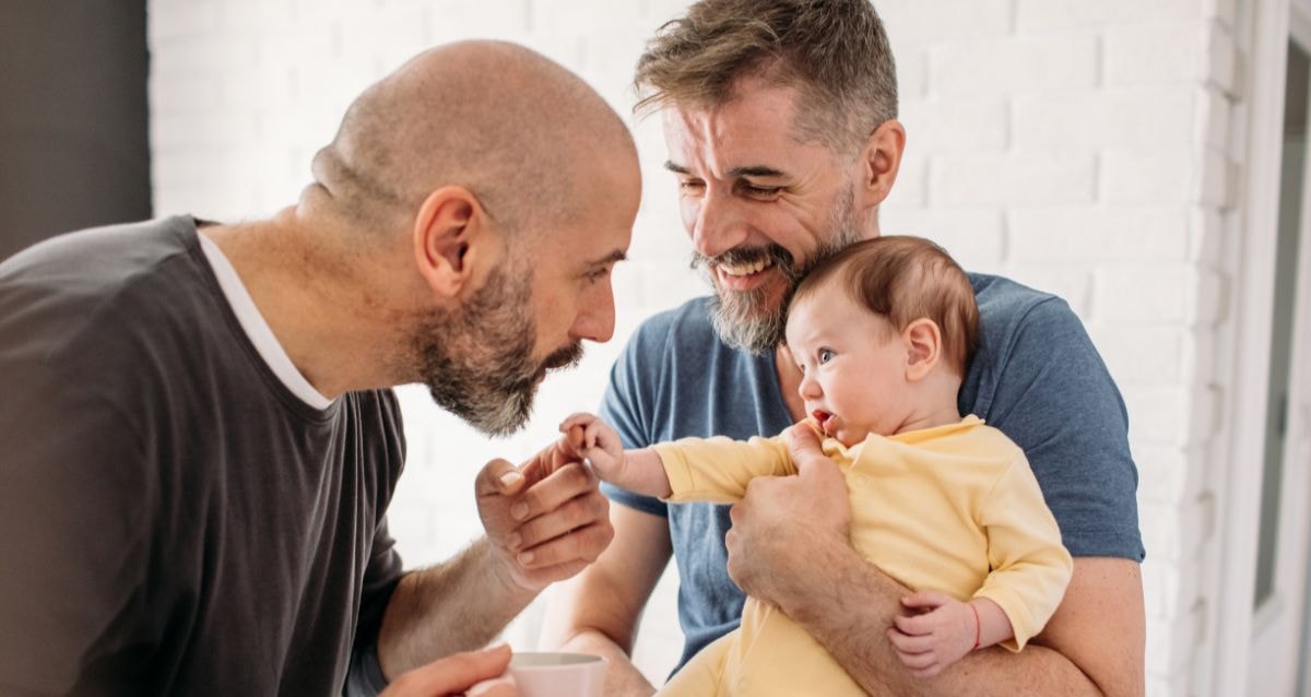 Gay couple sharing a moment with their baby born via surrogacy