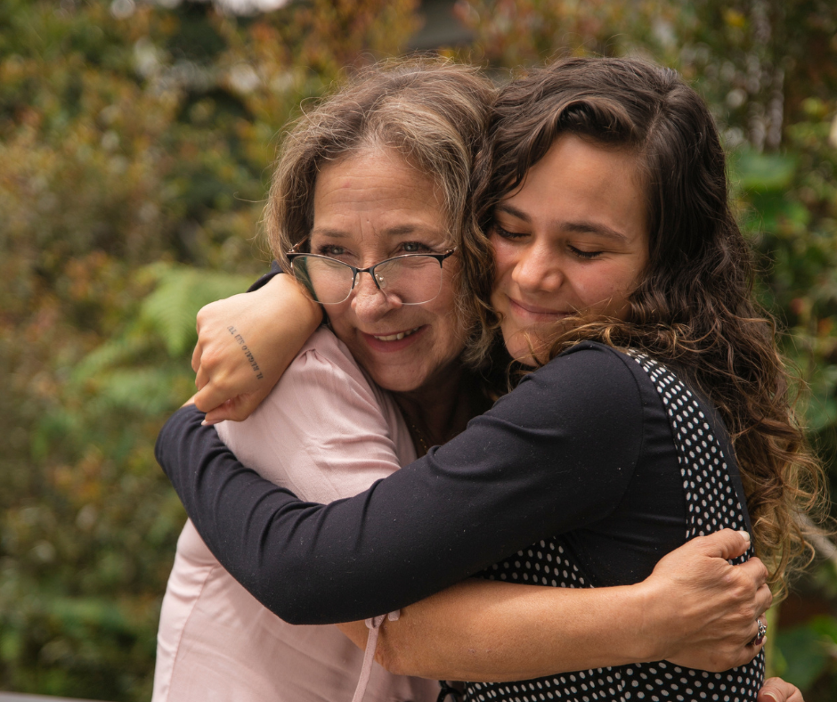 two women hug tightly