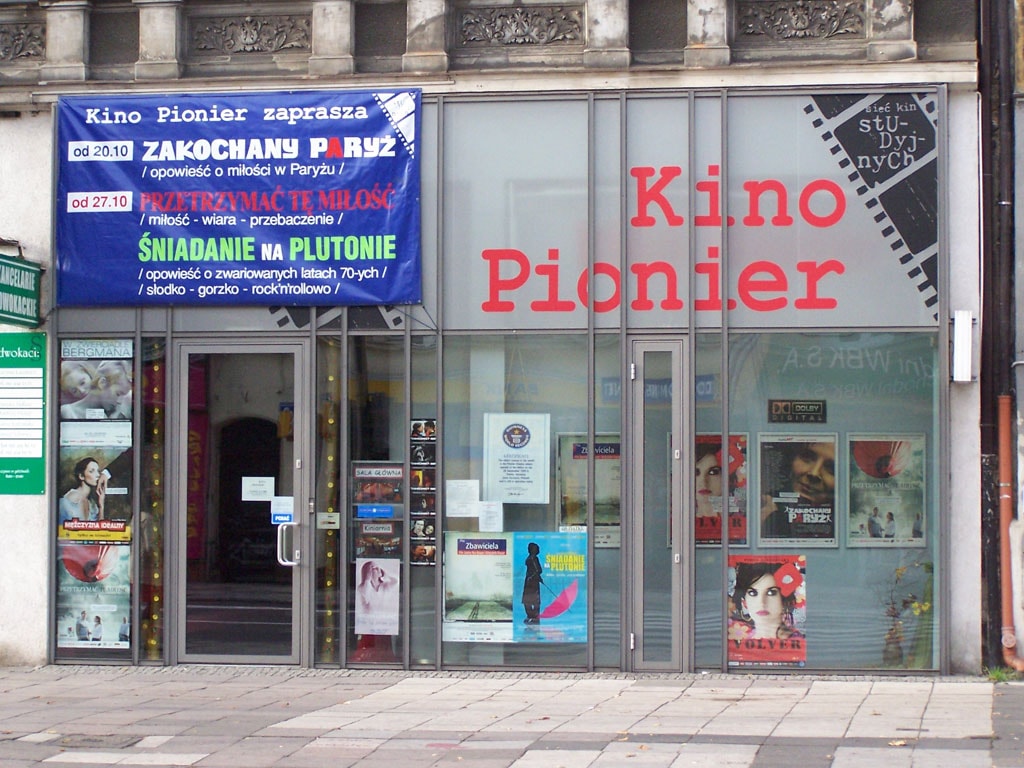 Widok na wejście do Kina Pionier w Szczecinie, które pokryte jest plakatami. Źródło: https://commons.wikimedia.org/wiki/File:KinoPionierSzczecin.jpg