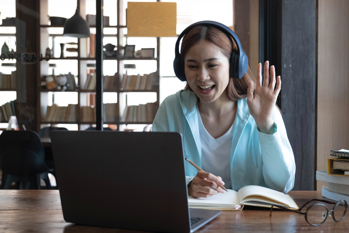 A Filipina candidate smiling and waving during a remote video interview.