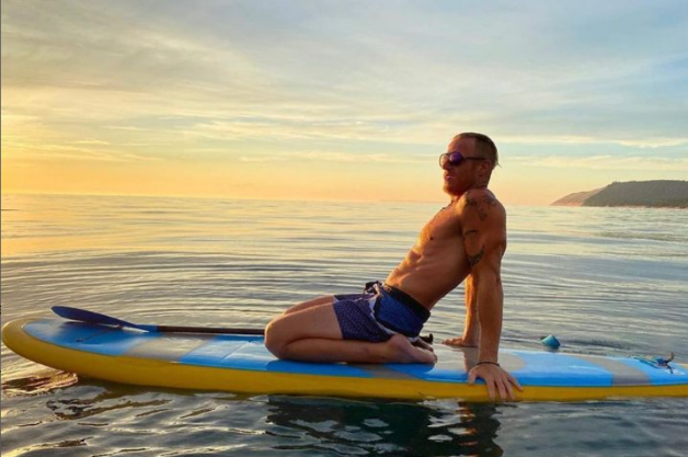 kneeling on a stand up paddle board