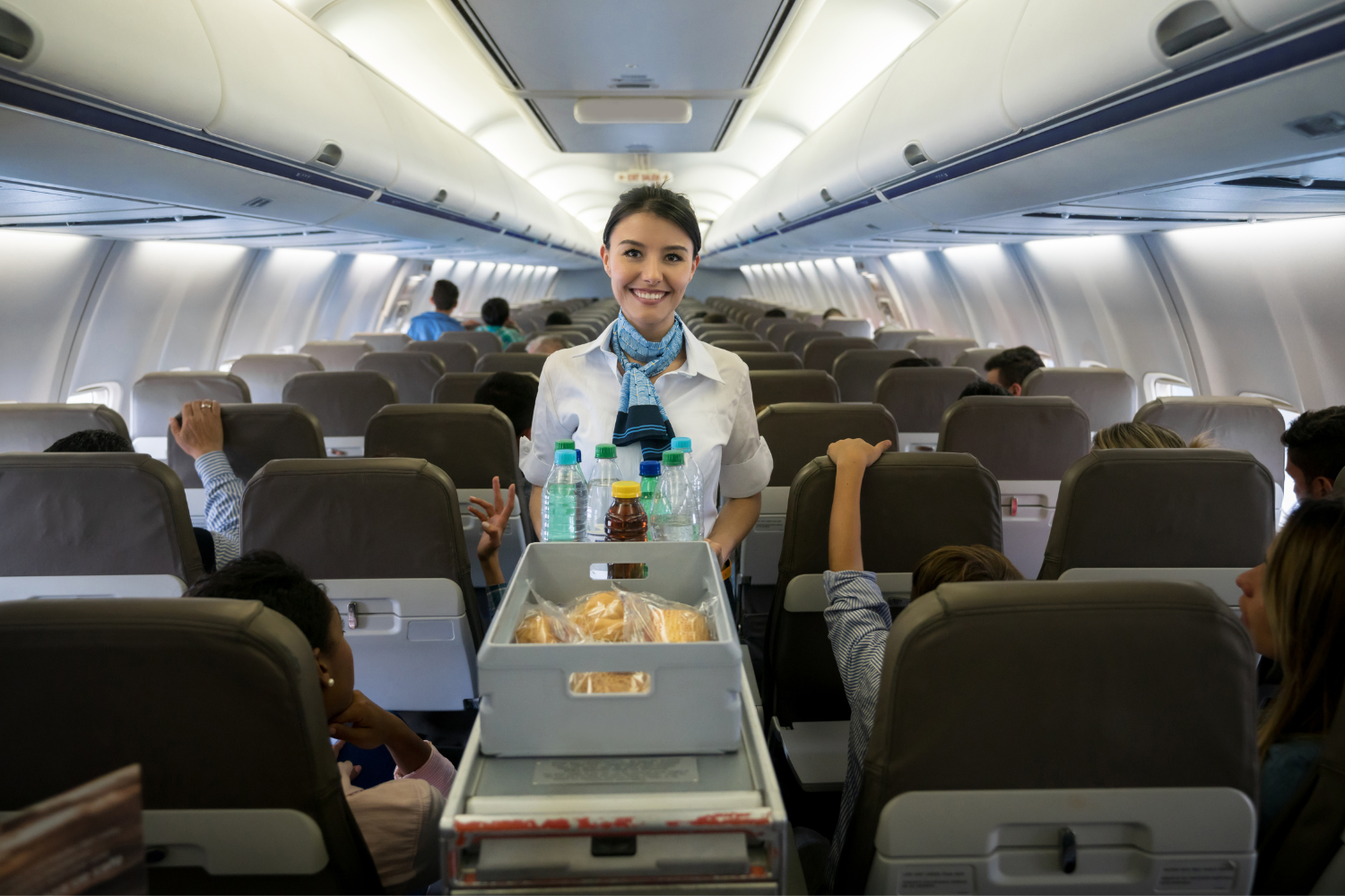 food and beverages served inside flight by a smiling airhostess