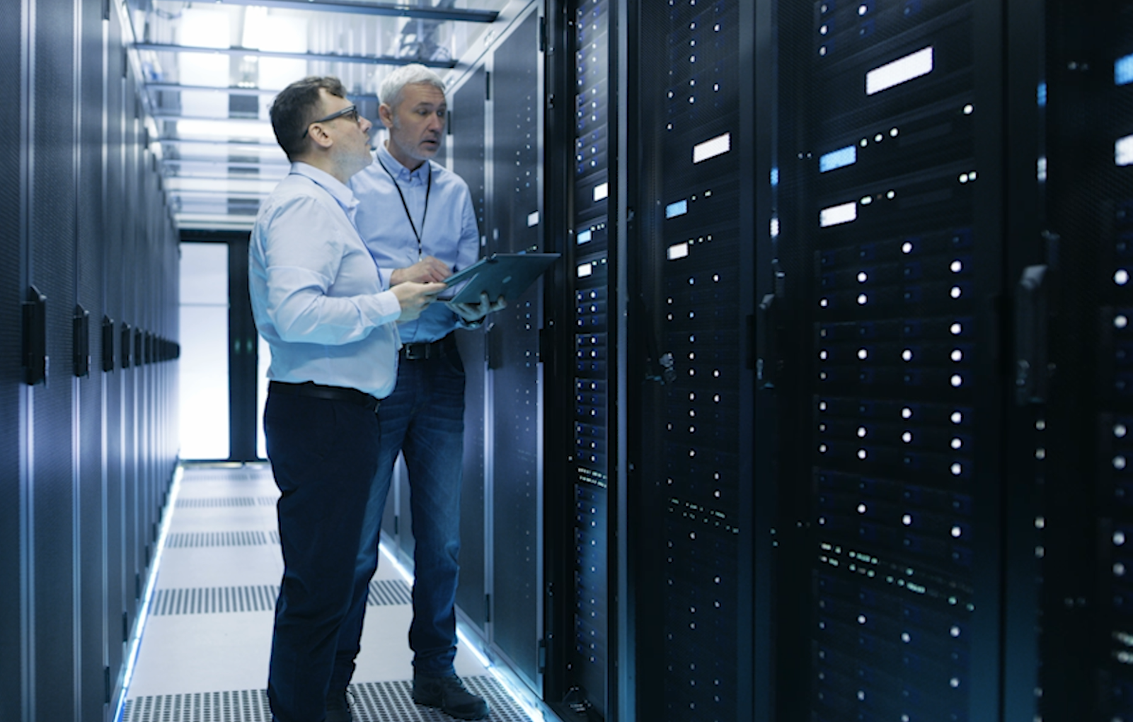 Two data center technicians consulting their ODT while on-site.