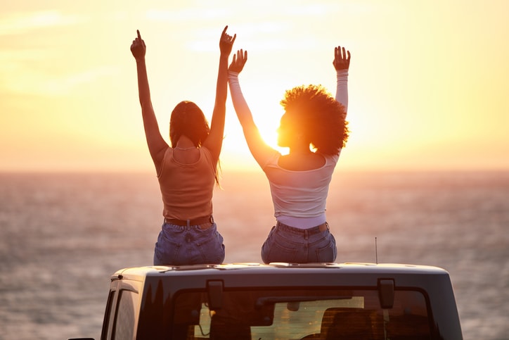 Two friends watching the sunset on the beach. 