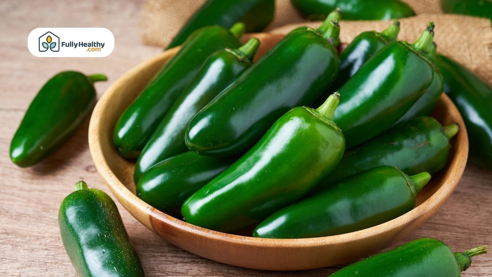 Wooden bowl filled with fresh green jalapeño peppers